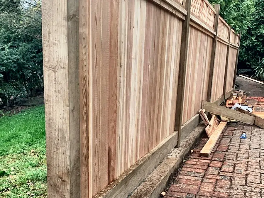 The fence going up, posts and boards on, base in