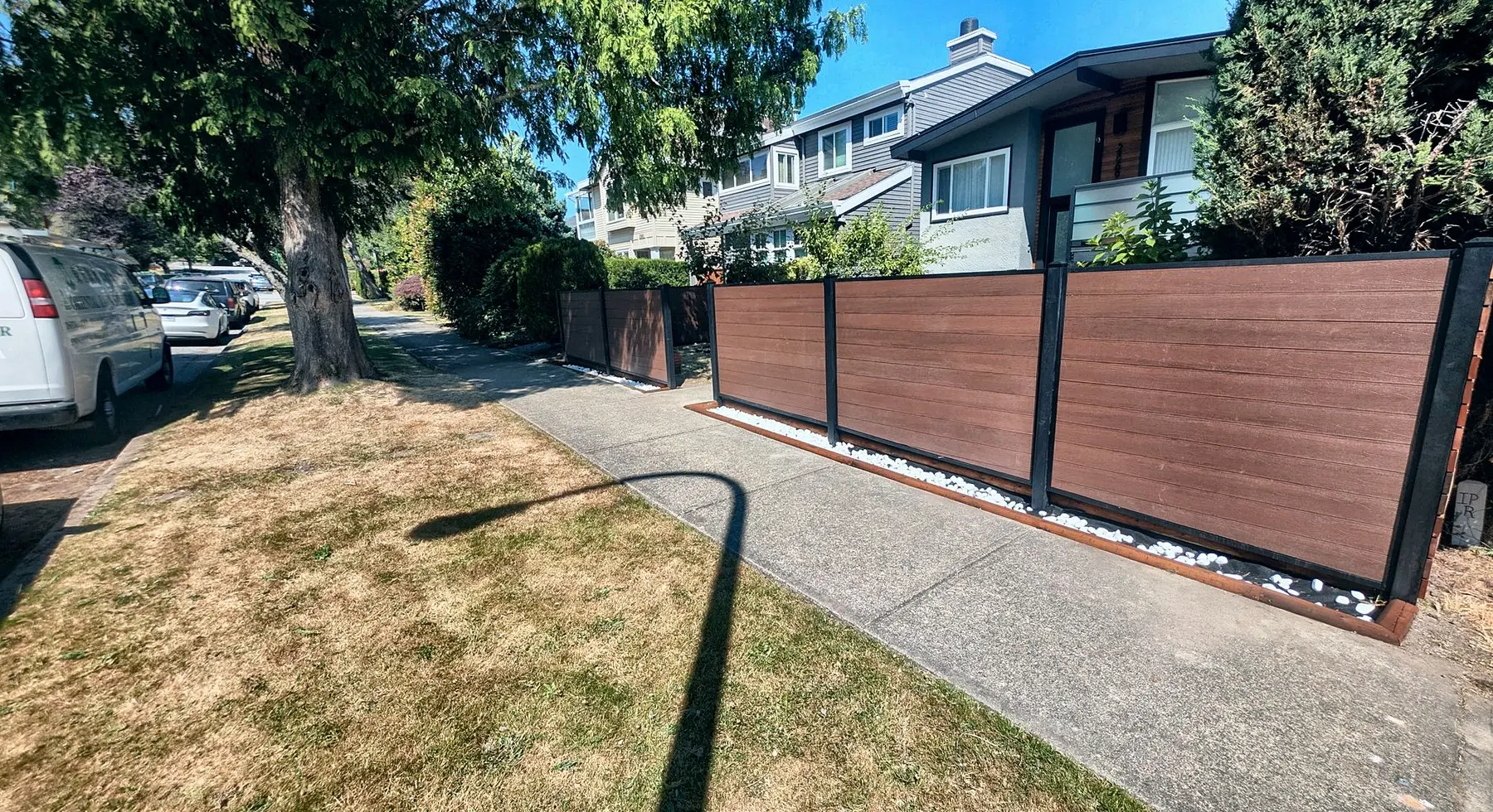 The composite fence along the sidewalk