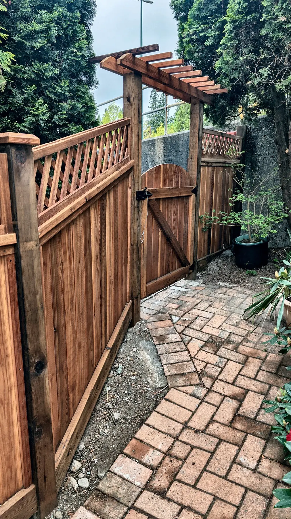 Arched cedar gate under an arbor, Coquitlam
