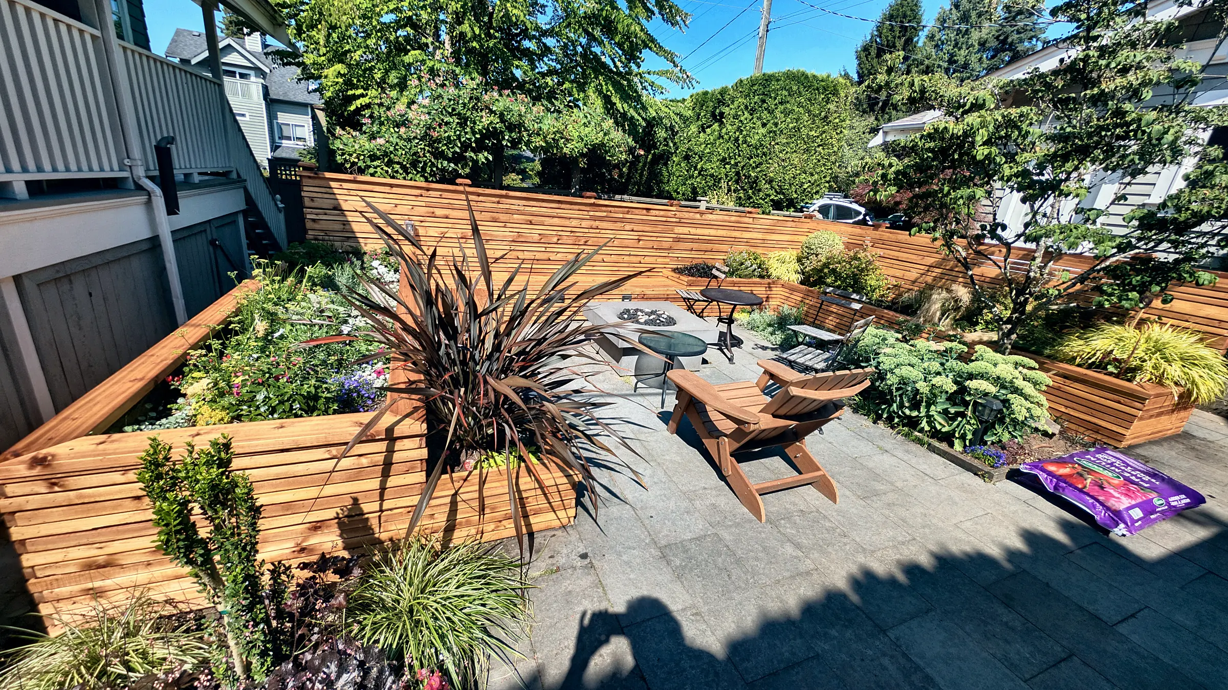 The fire pit corner with the new cedar wall behind it